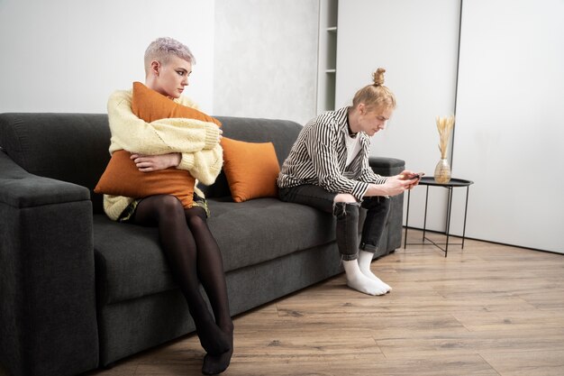 Full shot sad woman hugging pillow