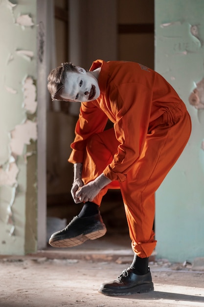 Full shot scary clown in abandoned building