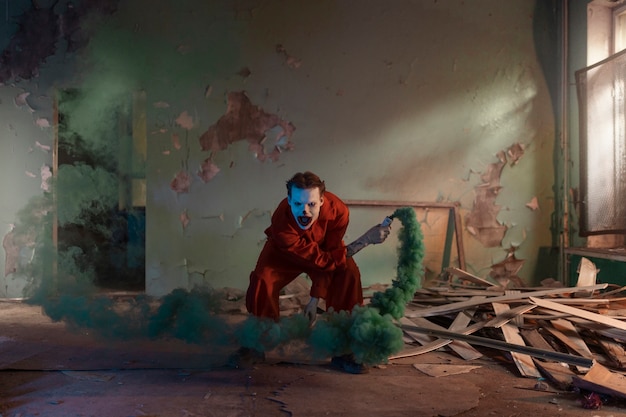 Full shot scary clown in abandoned building