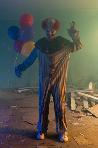 Full shot scary clown in abandoned building