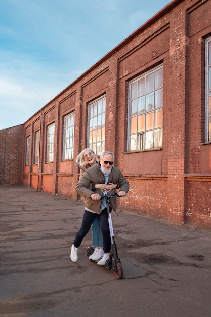 Free photo full shot senior couple on electric scooter