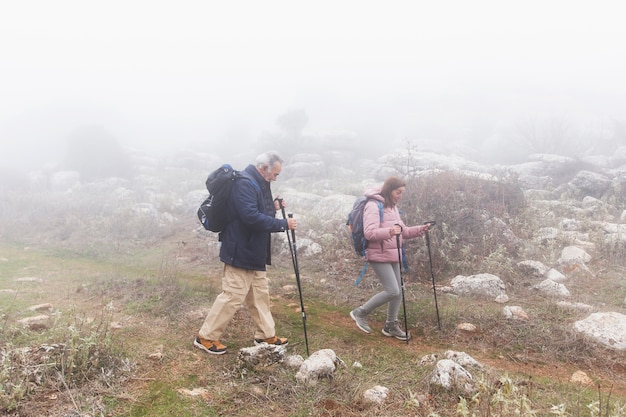 無料写真 一緒にハイキングするフルショットの年配のカップル