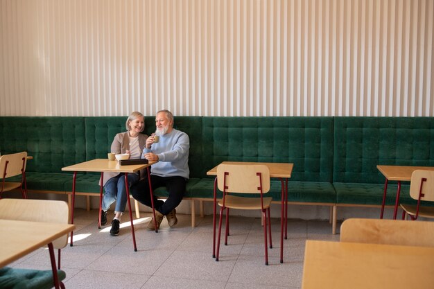 Full shot senior couple sitting at restaurant