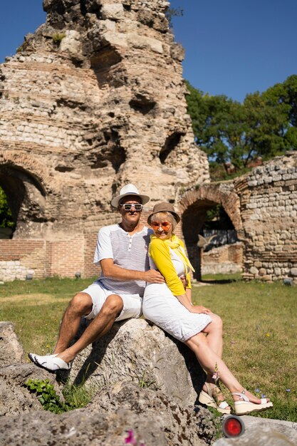 Full shot senior couple sitting on rock