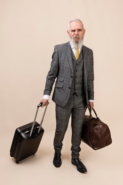 Full shot senior man carrying baggage