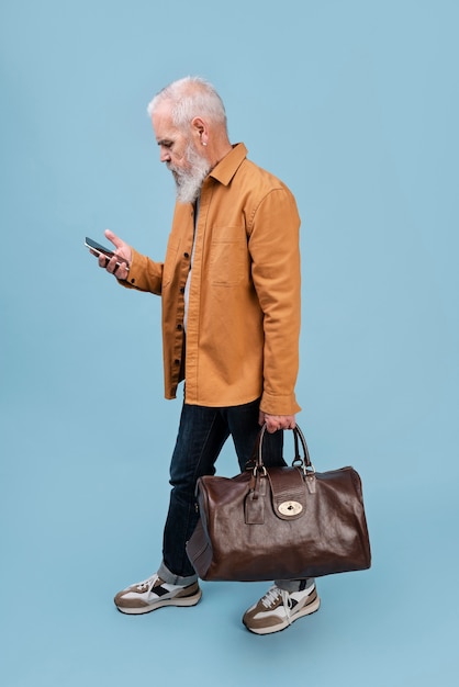 Full shot senior man carrying brown baggage