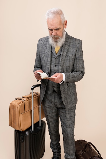 Free photo full shot senior man holding passport