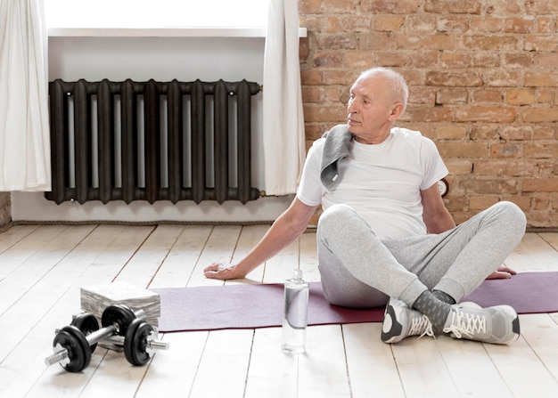 Free photo full shot senior man with yoga mat