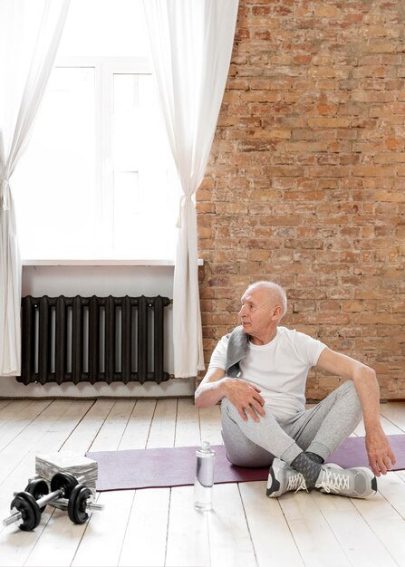 Full shot senior man on yoga mat