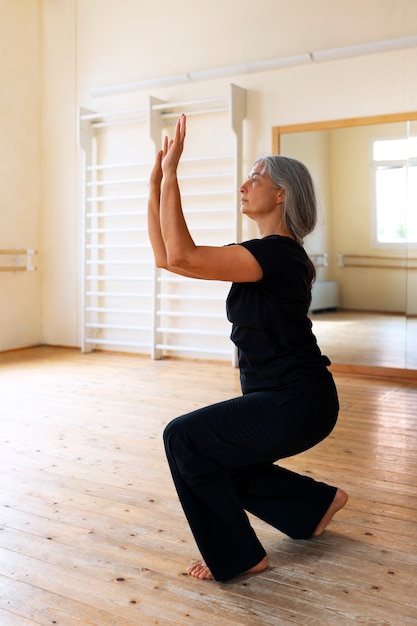 Full shot senior woman dancing in studio