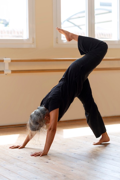 Free photo full shot senior woman dancing in studio