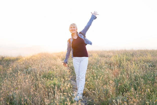 Free photo full shot senior woman posing on field