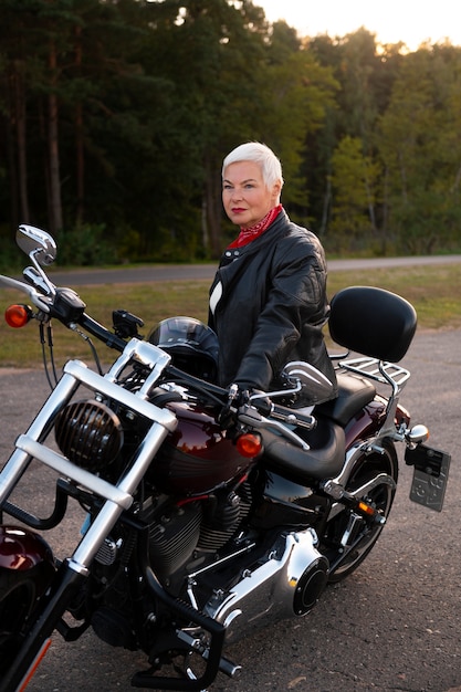 full shot senior woman with motorcycle
