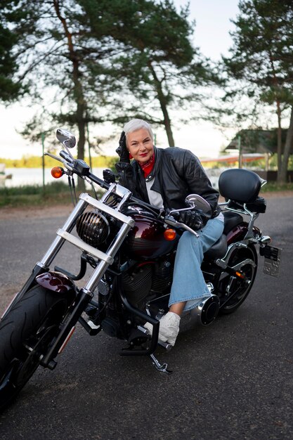 full shot senior woman with motorcycle
