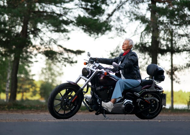 full shot senior woman with motorcycle