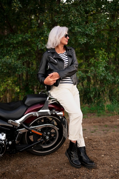 full shot senior woman with motorcycle