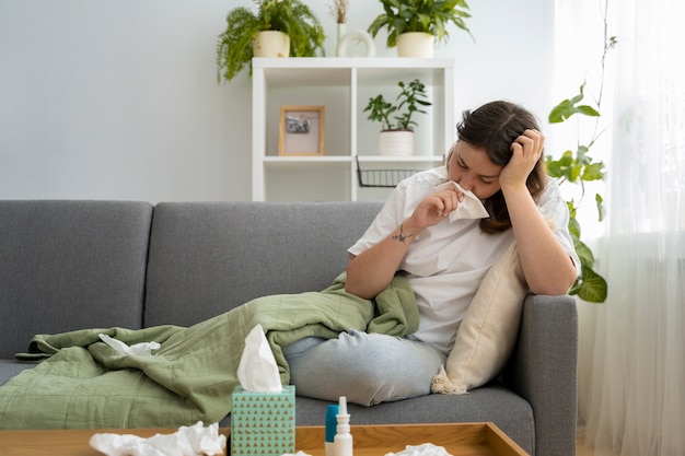 Free photo full shot sick woman on couch at home