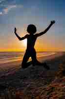Foto gratuita silhouette a figura intera che salta al tramonto