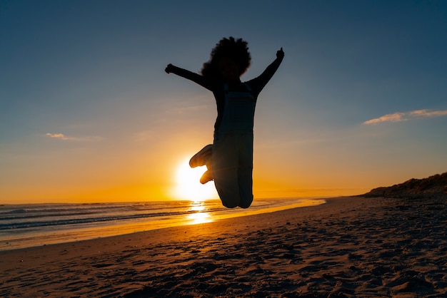 Foto gratuita silhouette a figura intera che salta al tramonto