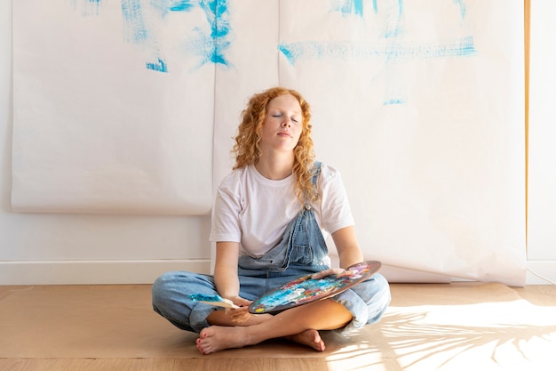 Full shot sitting woman with closed eyes