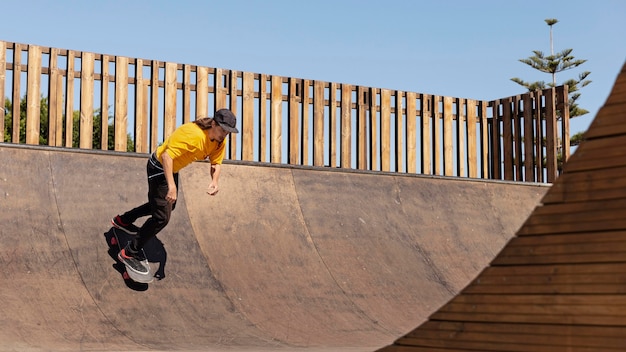 Full shot skateboarder with hat