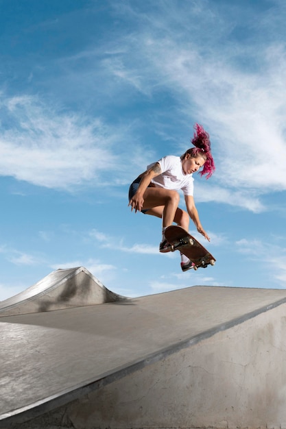 Бесплатное фото Конькобежец в полный рост прыгает с доской