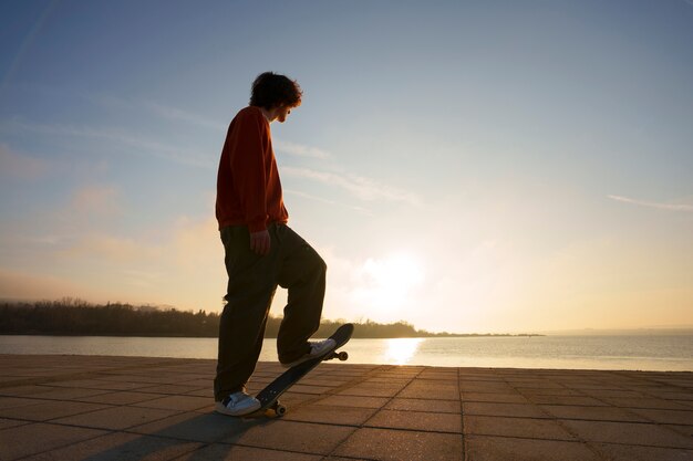 Full shot skater posing at sunset