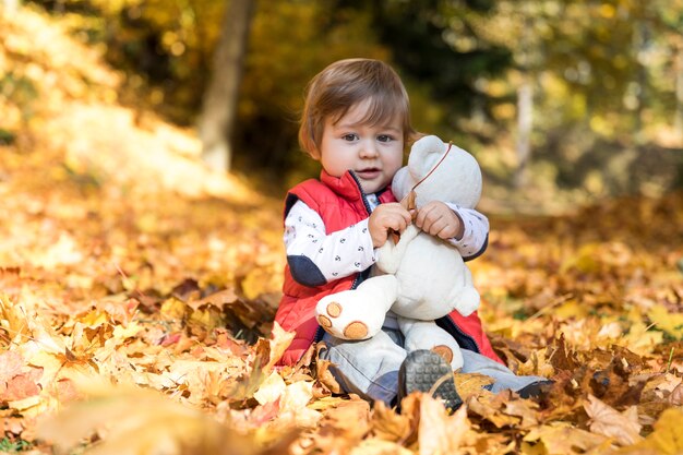 Full shot small baby hugging toy