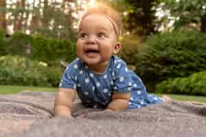 Free photo full shot smiley baby in nature