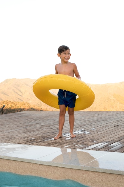 Бесплатное фото Полный смайлик мальчик со спасательным кругом