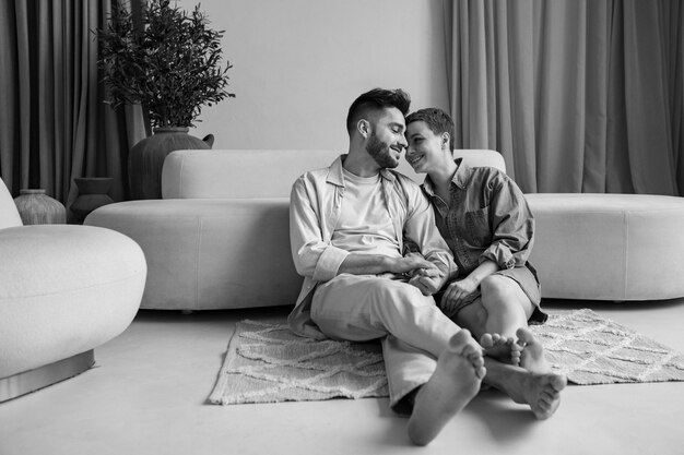 Full shot smiley couple sitting on floor