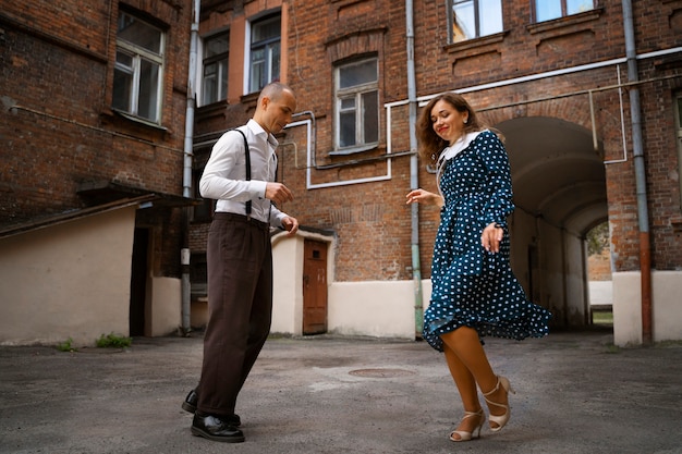 Free photo full shot smiley couple swing dancing