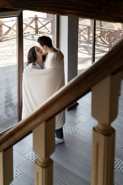 Full shot smiley couple with blanket