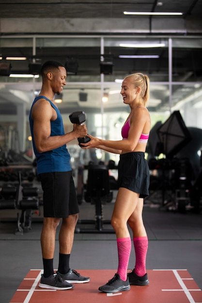 Full shot smiley fit people at gym