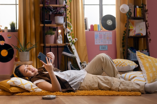 full shot smiley girl holding smartphone