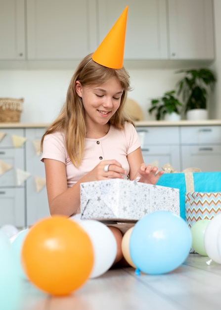 Free photo full shot smiley girl opening gift