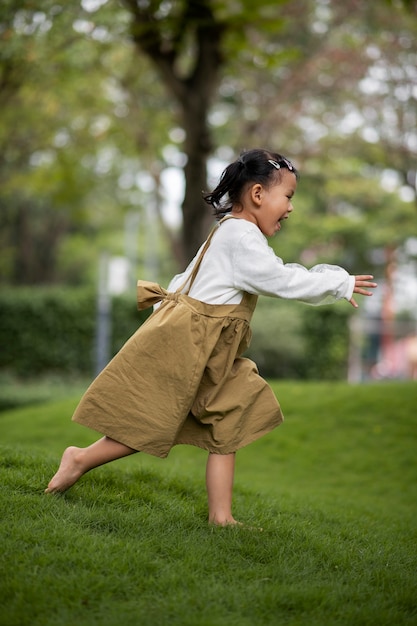 Full shot smiley girl running outdoors