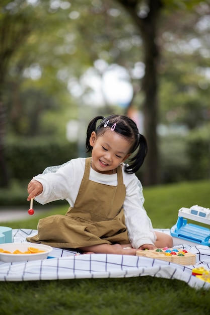 Free photo full shot smiley girl sitting on cloth