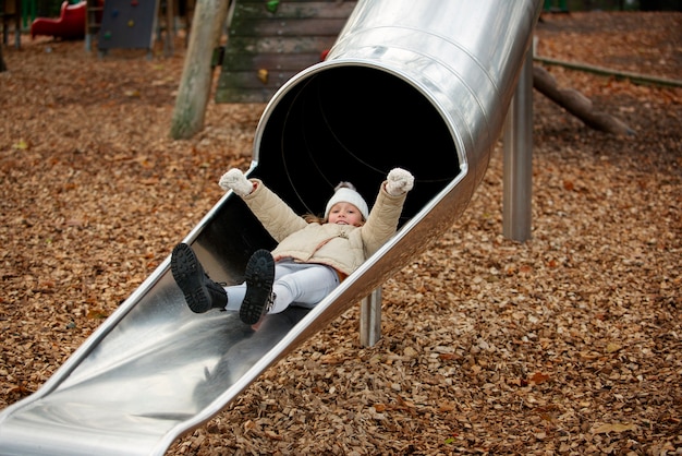 Full shot smiley girl on slide