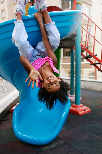 Full shot smiley girl on slide