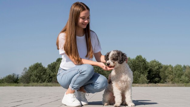 Full shot smiley girl with dog outdoors