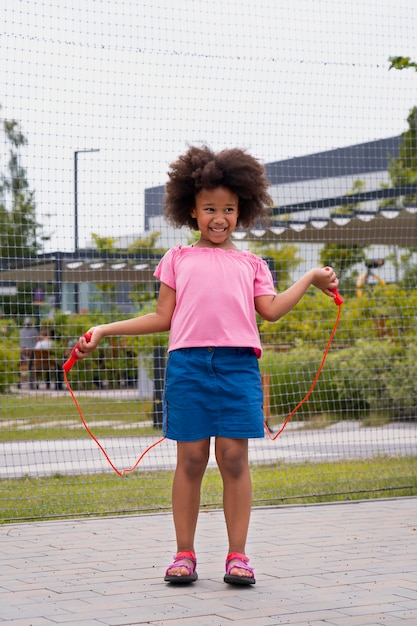 Full shot smiley girl with red rope