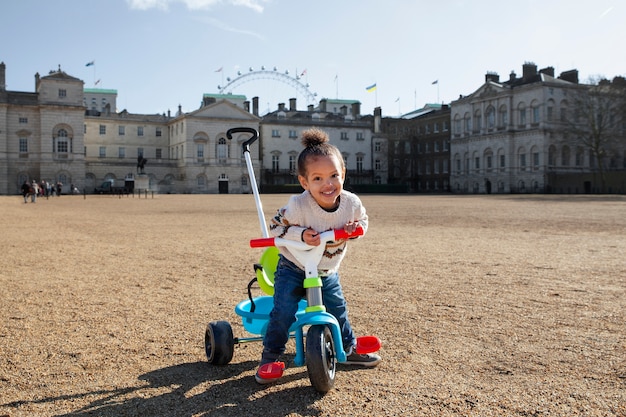 Full shot smiley girl with tricycle