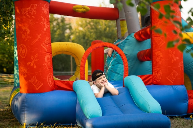 Free photo full shot smiley kid in bounce house