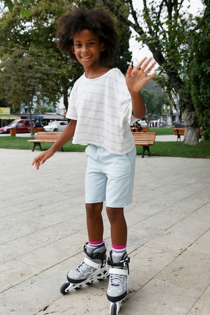 無料写真 ローラー スケートを保持しているフル ショット スマイリー子供