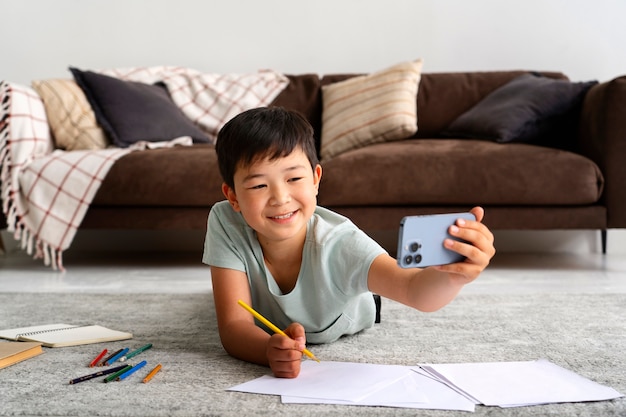 Full shot smiley kid laying on floor