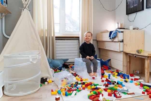 Full shot smiley kid sitting on container