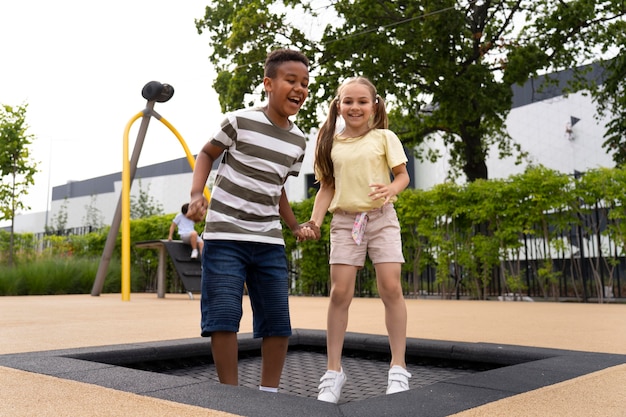 Foto gratuita bambini sorridenti a tutto campo che saltano insieme