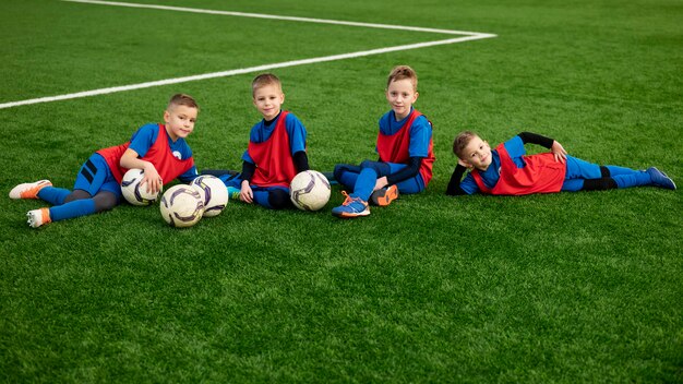 Full shot smiley kids sitting on grass