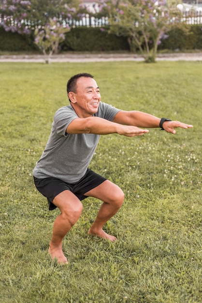 Full shot smiley man doing squats